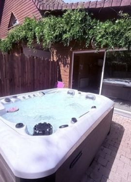 Spa extérieur sur terrasse en bois avec pergola végétale au Domaine de Stella